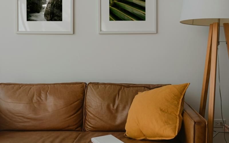 a couch with a lamp and photos on the wall