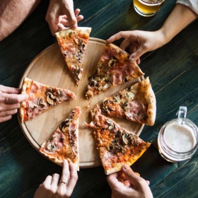 a group of people eating pizza